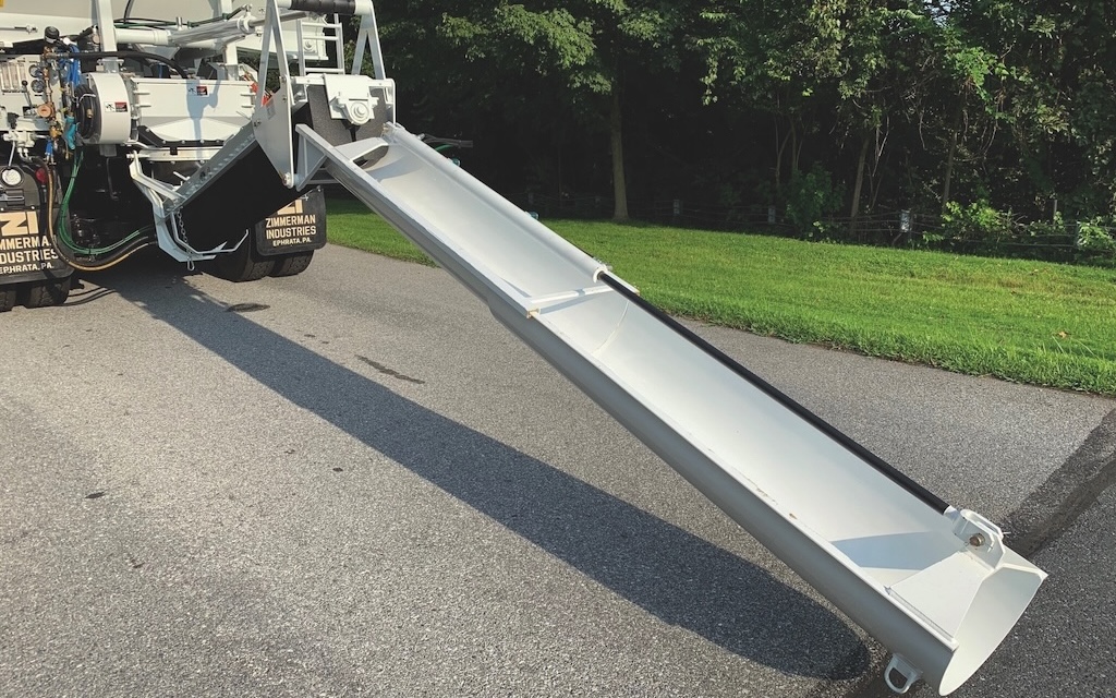 Power telescope chute system on the back of a volumetric concrete mixing truck.