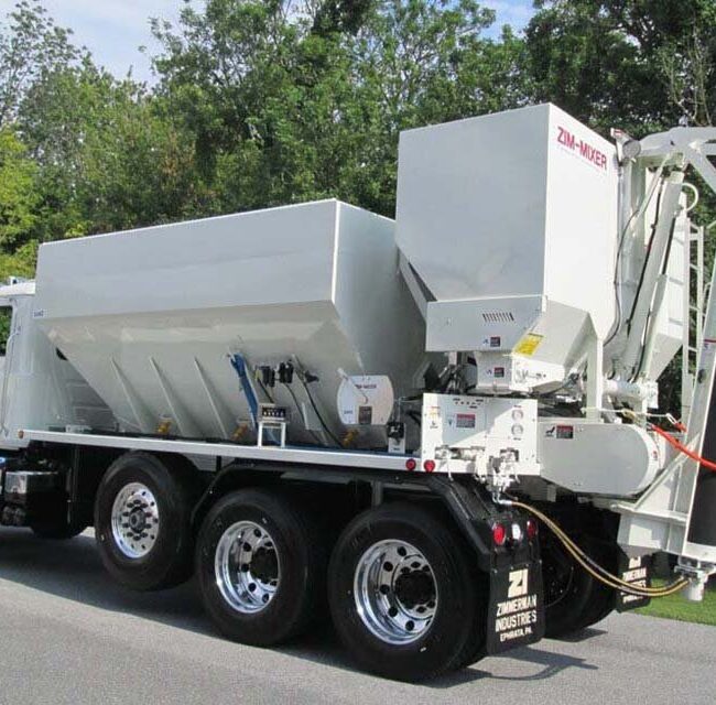 This volumetric concrete mixer is designed for the gunite or shotcrete producers. This is a view of the bins, tanks, control pannel and chute. This mixer is equipped with the patented dual chain material feed system - the most accurage in the industry.
