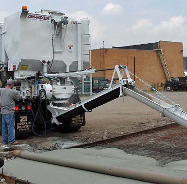 Concrete company on job site mixing concrete on demand. The products move through the auger system and pump fresh concrete down the chute for the perfect concrete pour.
