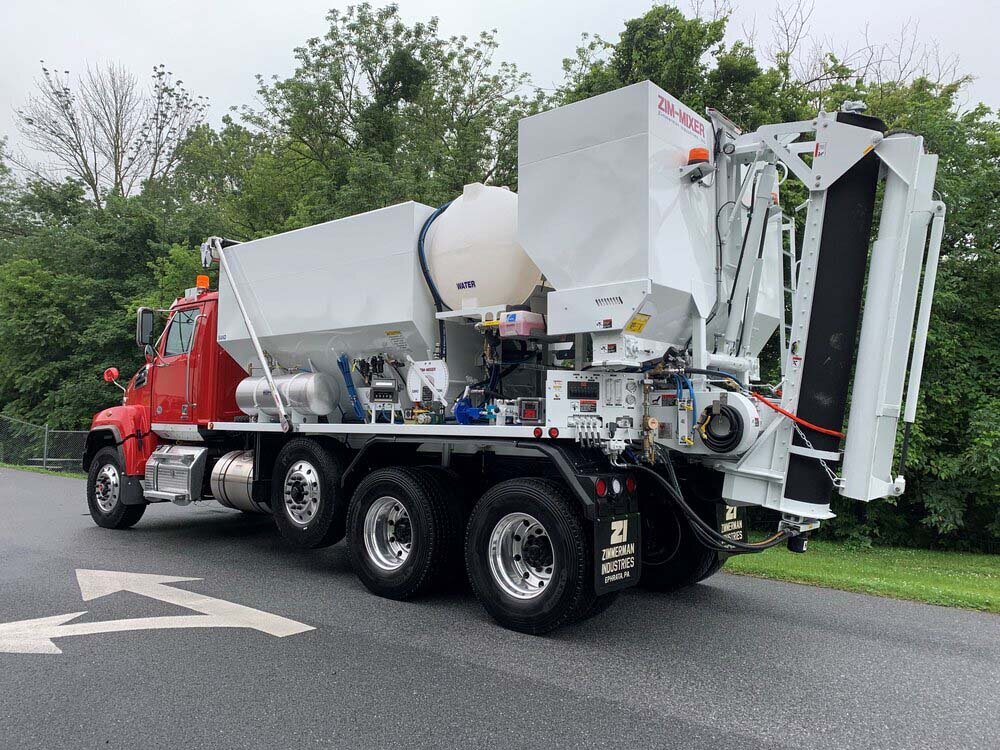 Rear discharge volumetric concrete mixing truck - bins and tanks loaded with materials to mix concrete on site for less waste and better ROI.